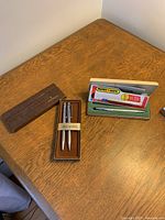 Photo of Sheaffer pen and pencil set in brown box with marked band and original packaging.