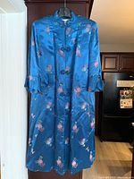 Front view of blue silk kimono with floral embroidery, Mandarin collar, and frog buttons.