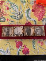 Top view showing the frame open with four circular photo sections containing vintage black and white photos.