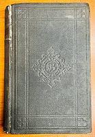Front cover of the hardcover book showing embossed design and wear on spine.