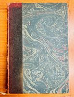 Closed front cover of one volume showing marbled pattern and textured spine.