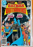 Front cover of Batman and the Outsiders #1 comic book showing Batman and several Justice League characters.