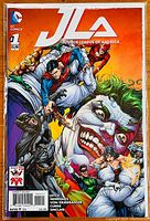 Front cover of the JLA Justice League of America #1 comic book showing the main characters and Joker artwork.