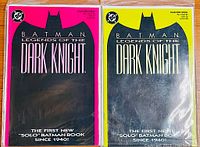 Two issue #1 Batman comics from Legends of the Dark Knight series with neon pink and yellow variant covers displayed side by side in protective sleeves.