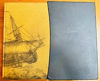 Front cover and slipcase of the book with yellow illustrated cover and black slipcase
