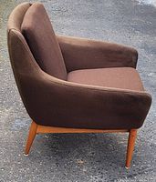 Right-side view showing profile of brown upholstered seat and teak base with angled legs