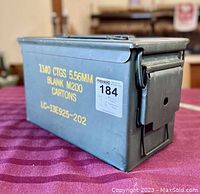 Side view showing yellow printed text with ammunition details and locking mechanism on lid.