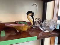 Three glass bird figurines displayed on shelf, showing overall lot and relative sizes.