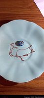 Rose gold chain and blue Murano glass Pandora charm displayed on a light blue ceramic dish.