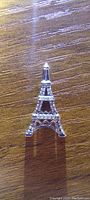 Front view of the 10k white gold Eiffel Tower pendant showing diamond accents.