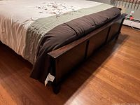 View of the footboard showing dark wood panels and overall design.