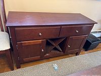 Full view of dark brown wooden sideboard with drawers, cabinets, and central wine rack.