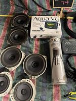 Top view of six differing sized speakers, Aqua-Vu Micro DVR box, and wrapped cylindrical item
