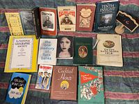 Fifteen assorted books displayed, titles visible on spines and covers, showing diversity in genres and authors.