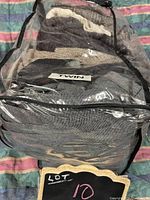Packed assorted men's sweaters, blazers, and pants inside a clear plastic garment bag labeled MINX