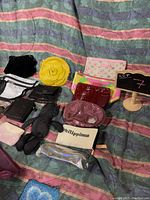 Photo showing 14 assorted purses and small bags arranged on striped fabric.