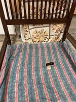 Close-up of the upper section of the dark wooden bed frame showing vertical slats and minor scratches.
