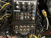 Close-up photo of the Groove Factory DMX4502 audio mixer showing inputs, outputs, and control knobs.