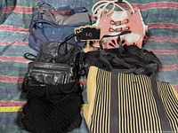 Eight assorted handbags and purses arranged on a multicolored fabric background showing details of shape, color, and material
