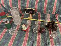 Wide shot showing full lot with pinwheel crystal vase, candleholders, Santa figurine, ornament, pine cones, and other holiday decor.