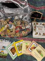 Photo showing clear plastic bag filled with wooden blocks and six colorful children's books arranged in front