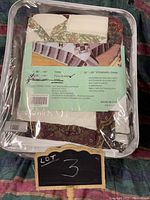 Packaged queen comforter set with label showing size and care instructions.