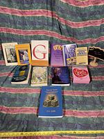 Photo showing 12 books laid out on fabric, including titles on tarot, astrology, and spells.