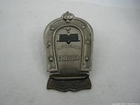 Front view of the metal horseshoe paper clip showing M. Myers & Son embossing and Good Luck text.