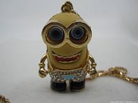 Close-up of Minion-shaped pendant showing details of face, eyes, mouth and rhinestones.