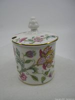 Side view of the jar showing floral patterns and lid with finial knob