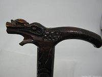 Close-up of the dragon head handle with turtle on top showing detailed wood carving and condition.