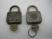 Two vintage Old Master Lock Co. 77 padlocks with original matching keys, showing front and side details.