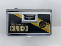Front view of binoculars showing Vancouver Canucks branding and central focusing knob