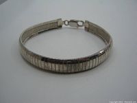 Full view of the sterling silver bracelet showing its rounded segmented design and clasp.