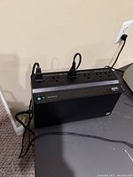 APC branded power outlet with multiple sockets and power switches plugged into the wall.