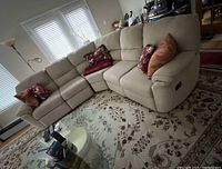 Front and side view of beige fabric L-shaped sectional sofa with manual recliner lever on right end