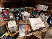 Wide shot of kitchen appliances and boxed items on countertop showcasing the lot's contents.