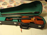 Open hard case with violin and bow in green felt interior