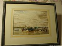 Full view of the framed watercolor painting depicting boats at a harbor under a cloudy sky.