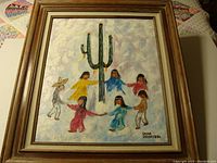 Frontal view of the framed oil painting showing six figures dancing around a cactus.