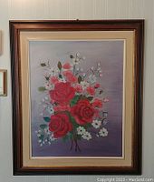 Frontal photo of the framed oil painting showing red roses, smaller white and pink flowers, and purple gradient background.