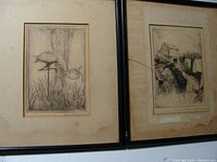 Pair of framed black and white etchings side by side, one showing a bird and the other a landscape with building, glass broken on right frame