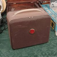 Closed Kodak Brownie 300 projector in a brown carrying case with a handle on top.