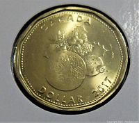 Reverse side of 2017 Canadian $1 coin featuring commemorative design with Canadian fruits and a smaller coin image, along with inscriptions.