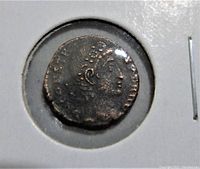 Front side of the ancient Roman coin showing a right-facing bust with a laurel wreath or similar headwear. Details are worn but visible.