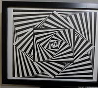 Framed black and white ink art showing a geometric spiral pattern with radiating stripes, captured front view.