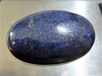 Polished oval labradorite gemstone with visible iridescence and blue hues.