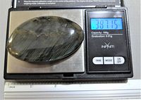 Photo of polished labradorite gemstone on digital scale showing weight 387.15 ct