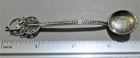Photo side angle showing the full silver spoon with coin bowl and twisted handle, ruler showing length at about 3.25 inches.