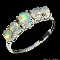 Close-up front angled photo of the sterling silver ring showing five fire opal cabochons with multicolor reflections.